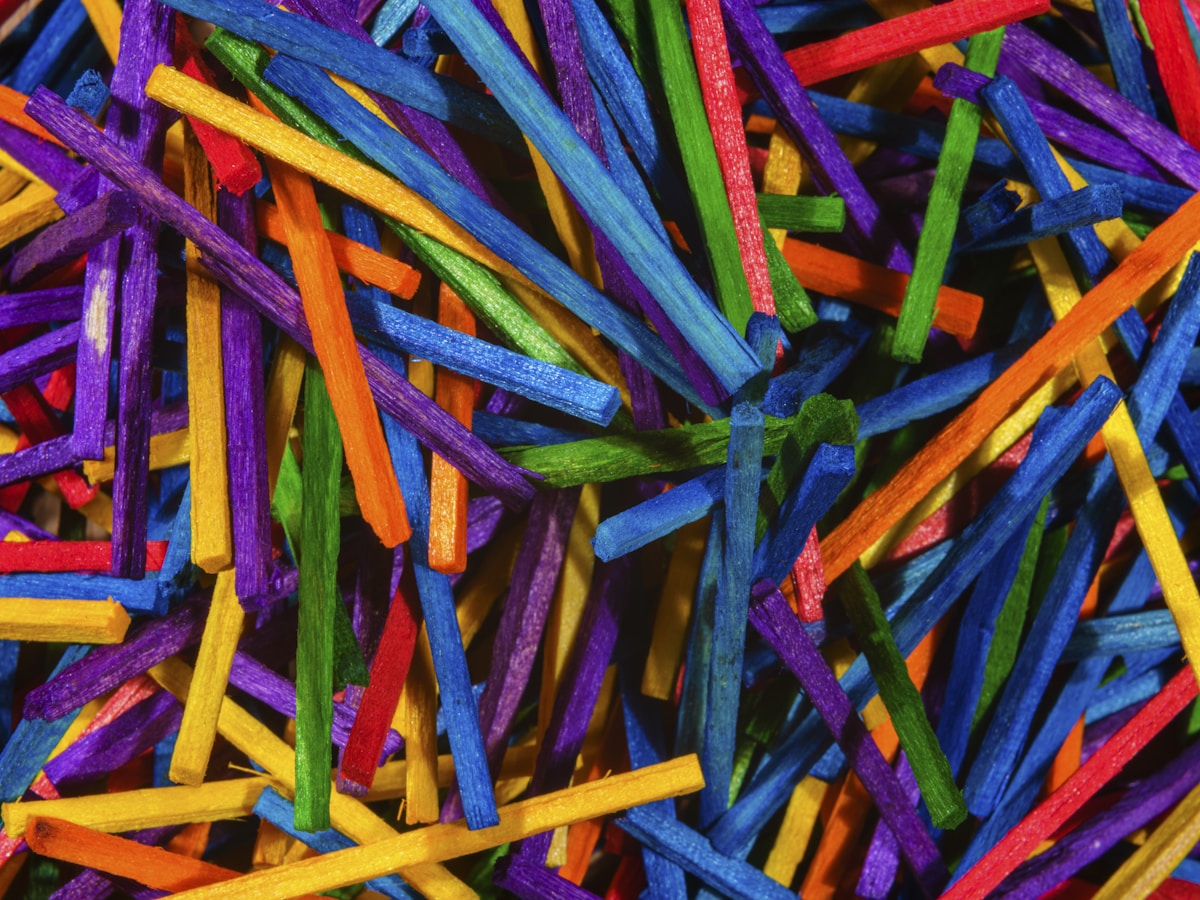 Colorful Mikado game sticks intertwined in macro view — a metaphor for legacy code where every piece depends on the others